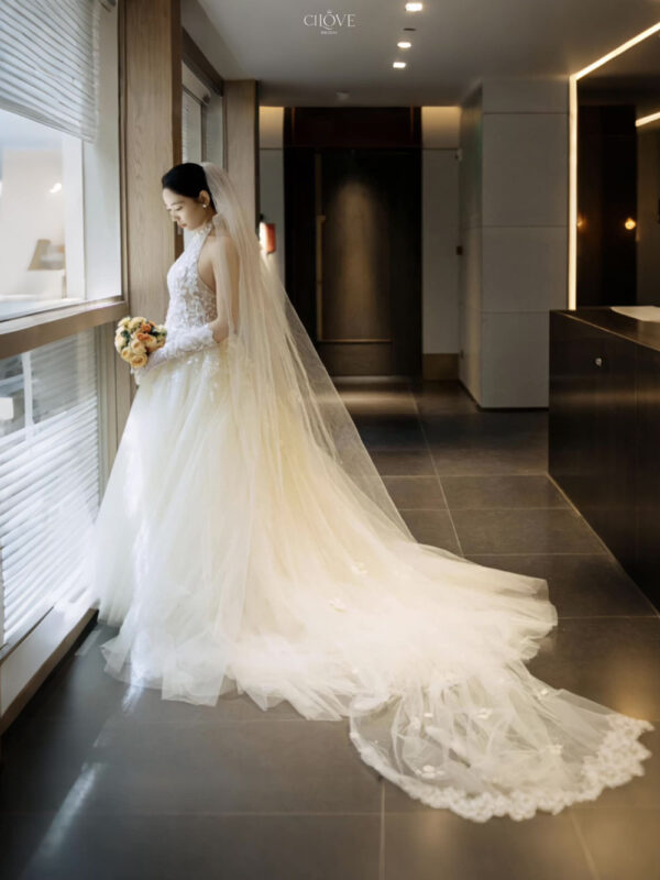 Váy cưới cổ yếm ren hoa nhẹ, dáng chữ A mềm mại, tôn vai và cổ cao.